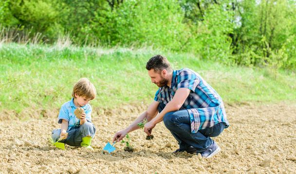 rich natural soil. Eco farm. happy earth day. Family tree. new life. soils and fertilizers. small boy child help father in farming. father and son planting flowers in ground. earth day. Garden bed - Foto, afbeelding