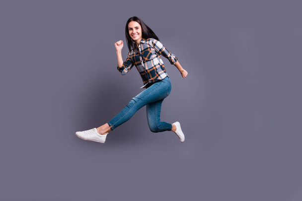 Full length side profile body size photo beautiful she her lady hold hands arms flight rush free low prices shopping mall store wear casual jeans denim checkered plaid shirt isolated grey background - Foto, Imagen
