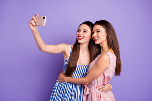 Közelről profil fotó két gyönyörű funky ő ő modellek női telefon okos telefon, hogy vegye selfies Toothy piros ajkak Pomádé rúzs kopás nyári ruhák elszigetelt lila lila háttér - Fotó, kép