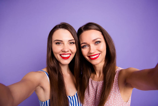 Close up photo two beautiful funny funky she her models ladies best buddies bonding perfect sunny weather make take selfies red lips toothy wearing summer dresses isolated purple violet background - 写真・画像