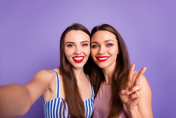 Close up photo two beautiful funny funky she her models ladies best buddies perfect sunny weather make take selfies show v-sign red lips toothy wear summer dresses isolated purple violet background - Фото, изображение