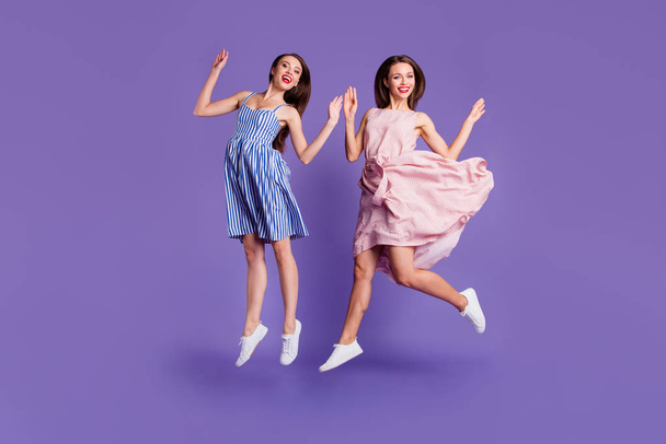 Full length body size photo two people beautiful funky she her models chic ladies jumping high best cheerleaders fans celebrating breakthrough wear summer dresses isolated purple violet background - Photo, image