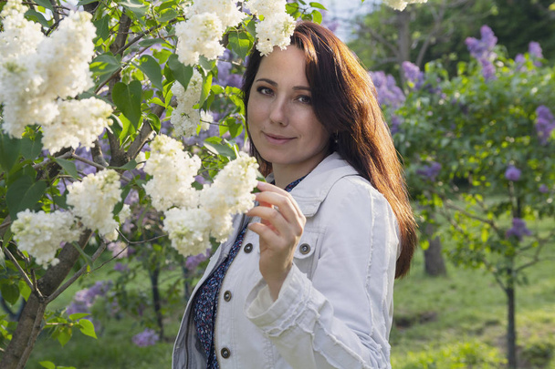 Hermosa mujer en el jardín entre las lilas. Gente
  - Foto, imagen