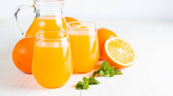 Primer plano de un vaso de zumo de naranja con frutas de naranjas sobre fondo de madera y piedra. Vitaminas y minerales. Concepto saludable de bebida y bebida
. - Foto, Imagen