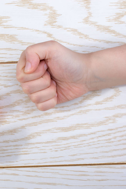 Руки, делающие камень, бумагу, ножницы жест на деревянном фоне
 - Фото, изображение
