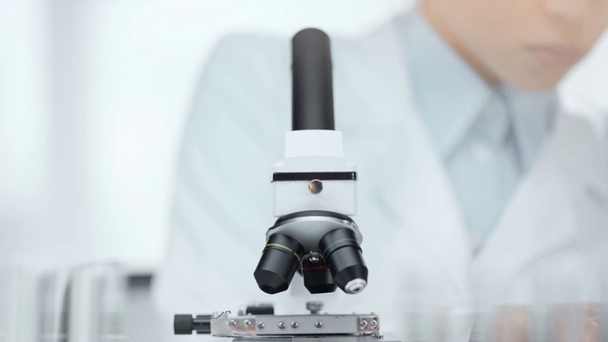 szelektív középpontjában az afroamerikai tudós szemüveg segítségével mikroszkóppal a hátsó lámpa - Felvétel, videó