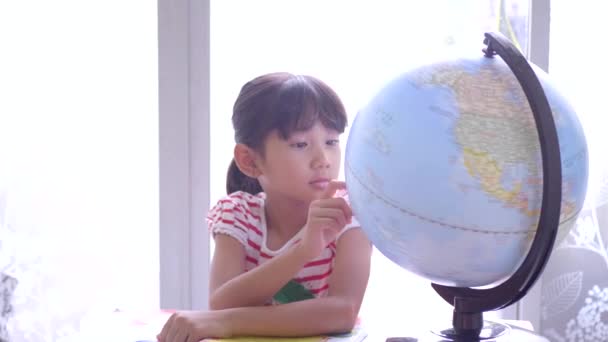 Niedliche kleine Mädchen, die auf Globus schauen. - Filmmaterial, Video