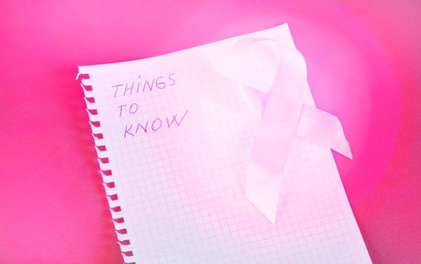 Things to know is written in Notepad with pink ribbon awareness breast cancer - Foto, afbeelding