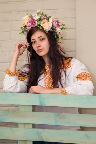 Portret van een meisje in een geborduurd overhemd en met een krans op zijn hoofd. Krans is een traditionele Oekraïense meisje hoofddeksels. Geborduurde shirt-traditionele Oekraïense kleding. - Foto, afbeelding