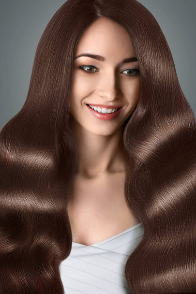 Haj. Mosolygó gyönyörű nő, barna hajú. Frizura. Hajápolás - Fotó, kép