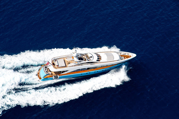 Аэрофото роскошной яхты, движущейся на скорости в открытом море с брызгами и волнами
 - Фото, изображение