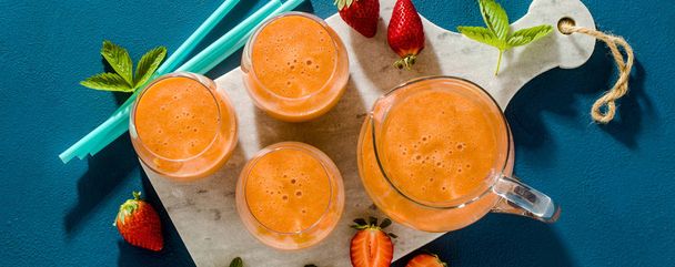 banner of strawberry smoothies in a carafe and glasses on a blue - Photo, Image