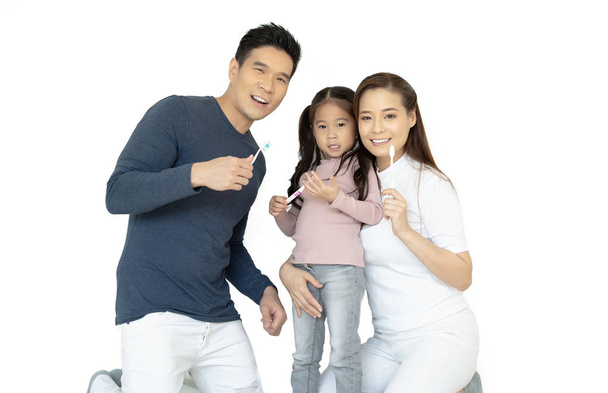 Портрет улыбающейся счастливой азиатской семьи, чистящей зубы и улыбающейся
 - Фото, изображение