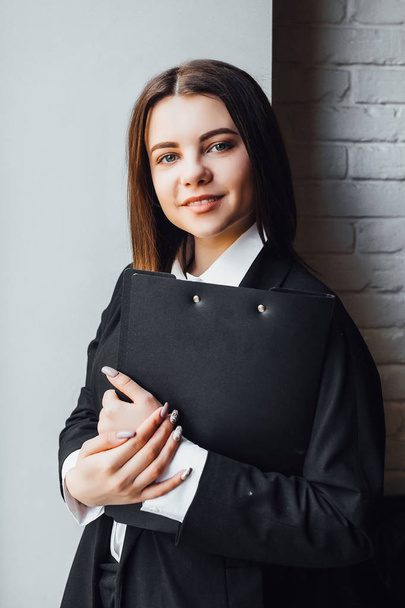 Młoda bizneswoman z czarnym folderem w rękach, selektywne skupienie - Zdjęcie, obraz