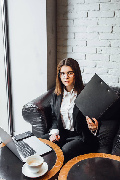 Pretty young businesswoman using laptop sitting at workplace - Φωτογραφία, εικόνα