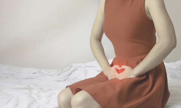 Naiset käyttävät punainen hame Käytä kättä naarmuttaa vagina.Genitaalinen kutina aiheuttama sieni alusvaatteisilla.Älä keskity esineitä
. - Valokuva, kuva