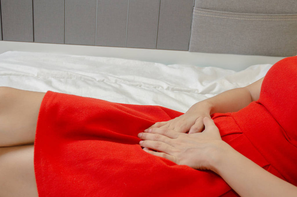 Ženy nosí červenou sukni Pomocí ruky poškrábat vagina.Genitální svědění způsobené houbou ve spodním prádle.. - Fotografie, Obrázek