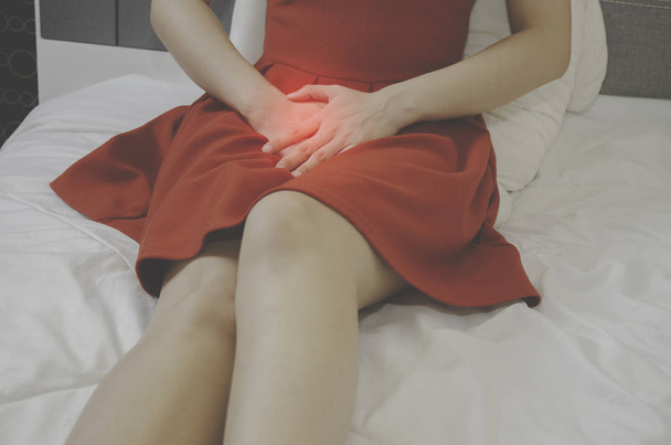 Kobiety noszą czerwoną spódnicę Użyj dłoni do drapania pochwy.Grzybica narządów płciowych spowodowane przez grzyba w bieliźnie.. - Zdjęcie, obraz