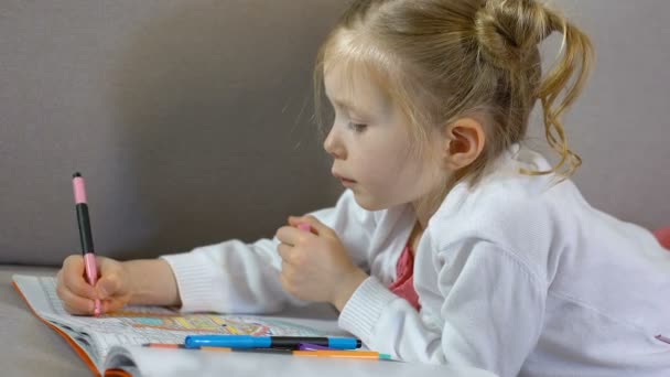 Preschool female drawing with markers in coloring book, childhood leisure, art - Séquence, vidéo