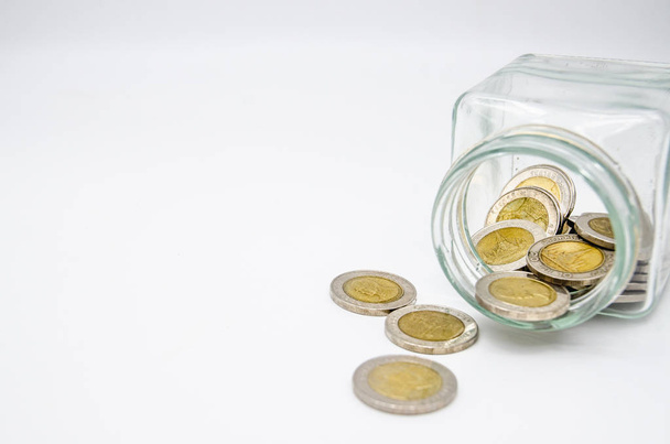 Peníze 10 Thajská baht je ve skleněné láhvi. Bílé pozadí v pojetí úspor peněz pro budoucnost. - Fotografie, Obrázek