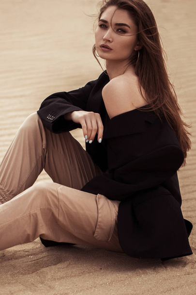Женский портрет в стиле Бохо сидя на песке, модная одежда
 - Фото, изображение