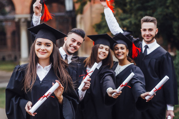 Studenten met diploma's, focus op de voorgrond - Foto, afbeelding