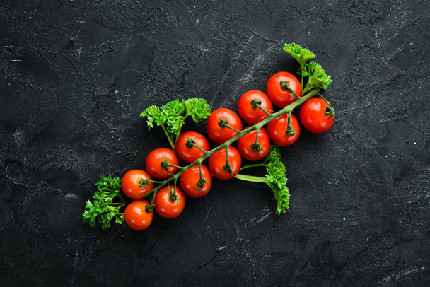 Fresh cherry tomatoes on a twig. Vegetables. Top view. Free space for your text. On a wooden background. - Foto, afbeelding