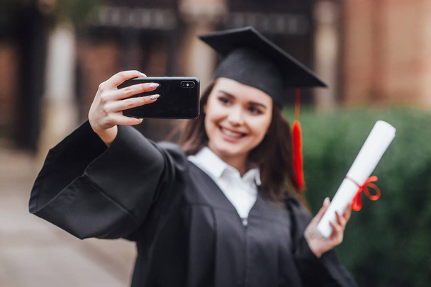Gorgeous woman with diploma making selfie - Zdjęcie, obraz
