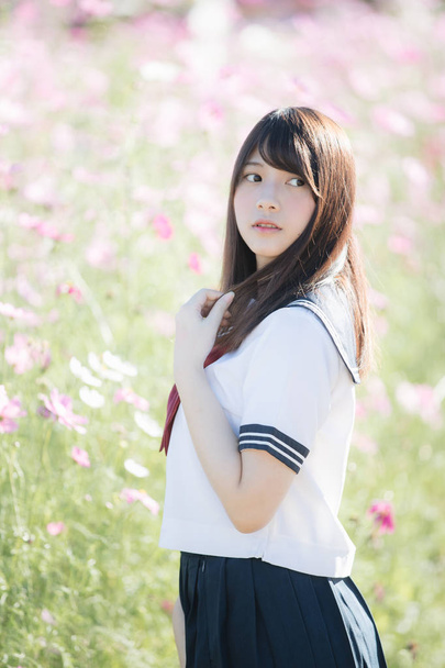 Portrait of Japanese school girl uniform with cosmos flower  - Photo, Image