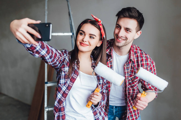 Young couple doing repairs in apartment and making selfie - Foto, Imagem