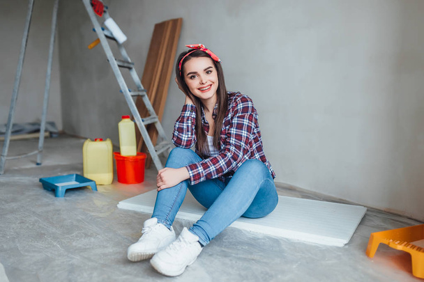 Приваблива молода жінка робить ремонт вдома
 - Фото, зображення