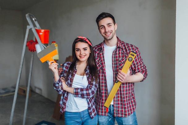 Portrait of couple doing redecoration in apartment, selective focus - Photo, image