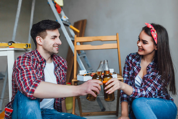 Homme tenant boîte avec pizza avec femme assise à côté et boire de la bière
 - Photo, image