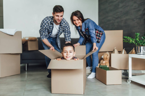 Happy family with cardboard boxes at new home - Foto, Imagen