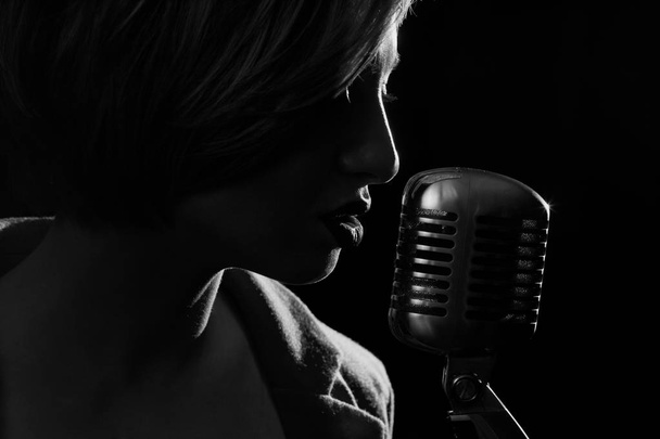 Silhouette of singing woman with retro microphone - Foto, Imagen