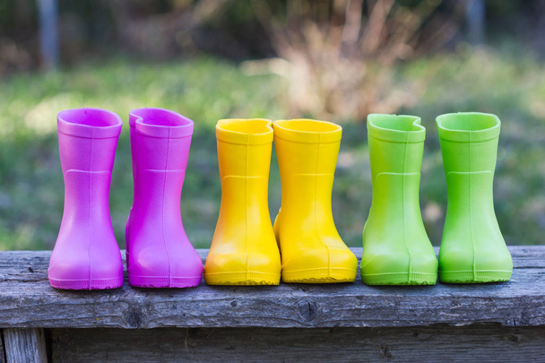 Multicolored rubber boots. Pink, yellow, green, rubber boots outdoors. - Fotoğraf, Görsel