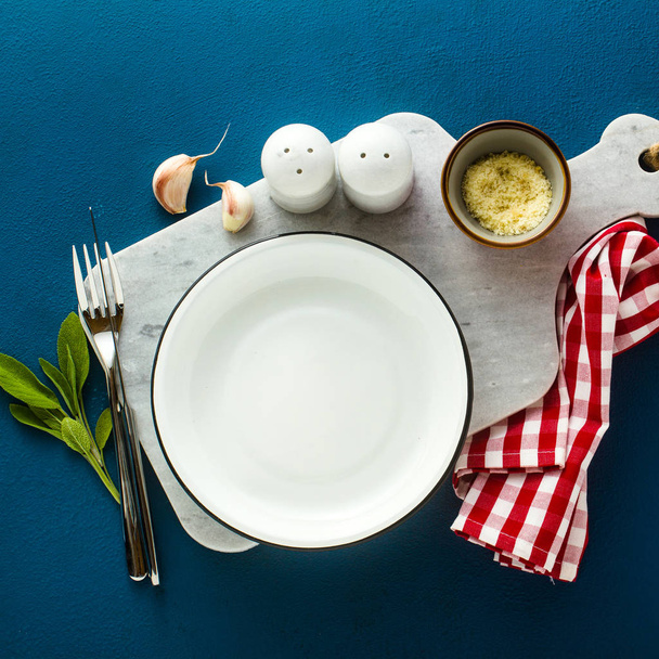 empty served plate on marble serving board and blue spice backgr - Foto, Imagem