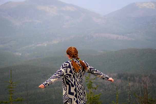 Rudy girl in the mountains in a poncho. Carpathian Mountains. Tr - Zdjęcie, obraz