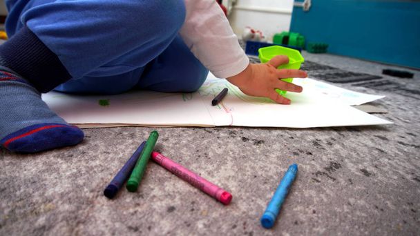 The child learns to draw wax crayons on the floor - Photo, Image