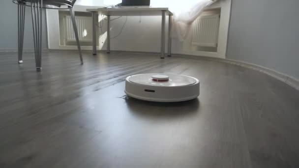 Moderne robot stofzuiger reinigt de vloer in de woonkamer. - Video