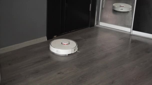 Nowoczesna robota odkurzacza czyści podłogę laminowaną. - Materiał filmowy, wideo