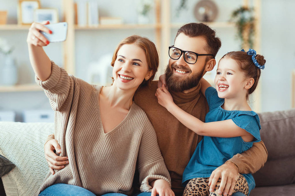 iloinen onnellinen onnellinen perhe äiti isä ja lapsi ottavat selfiet, ottavat
 - Valokuva, kuva