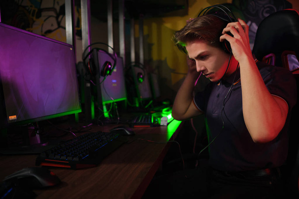 Cyber-Sport. Entspannter Spieler ruht sich in der Pause zwischen den Spielen auf seinem bequemen Spielstuhl aus - Foto, Bild