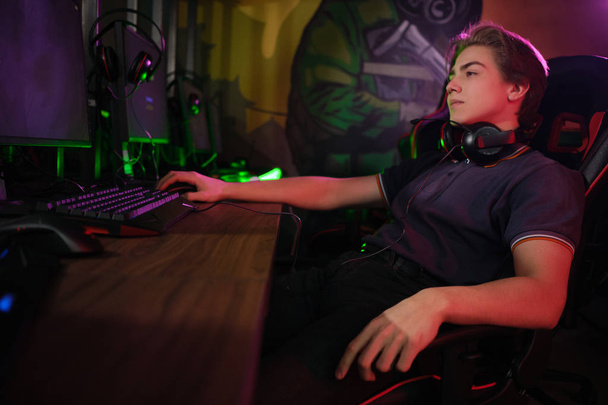 Desporto cibernético. Jogador relaxado descansa no intervalo entre os jogos em sua cadeira de jogo confortável
 - Foto, Imagem