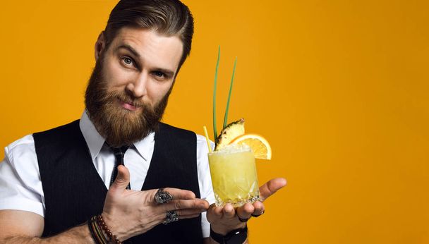 bearded barman with beard holding cocktail in waistcoat - Photo, Image