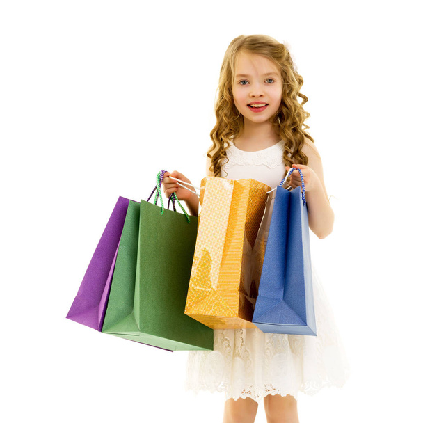 Little girl with multi-colored bags in their hands. - Photo, Image