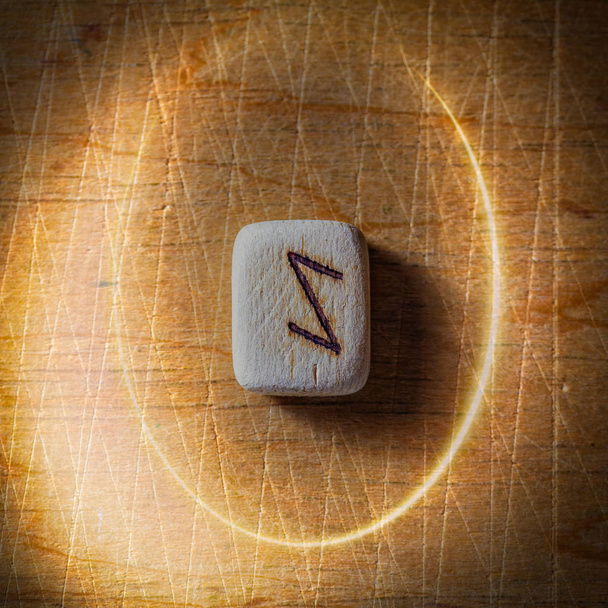 Eihwaz. Handmade scandinavian wooden runes on a wooden vintage background in a circle of light. Concept of fortune telling and prediction of the future - Photo, Image
