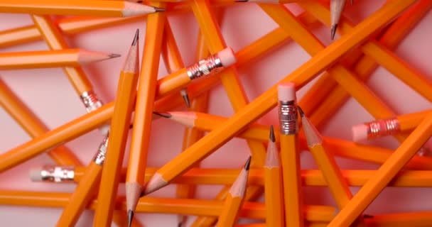 gelb beschichtete Bleistifte, die in Zeitlupe rotieren. Nahaufnahme von oben, aufgenommen mit roter 6k-Kamera - Filmmaterial, Video