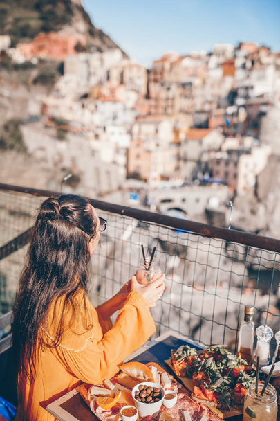 Kaunis nainen aamiaisella ulkona kahvilassa hämmästyttävä näkymä Cinque Terre
 - Valokuva, kuva