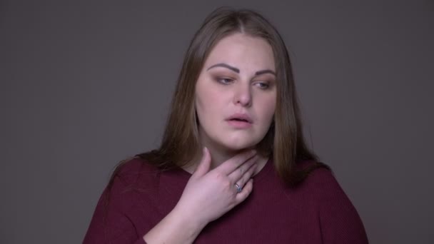 Closeup portarit of young overweight caucasian female a sick throat coughing with background isolated on gray - Footage, Video